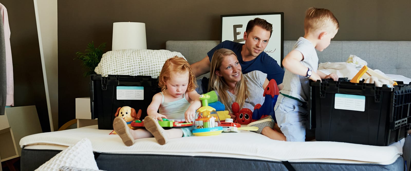 Family relaxing on a bed after a move